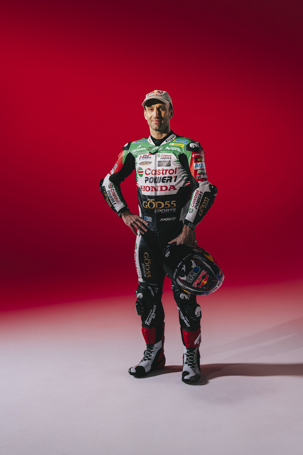 Johann Zarco debout combinaison MotoGP Dafy Moto casque Shark main gauche fond rouge Nicolas Jacquemin photographe