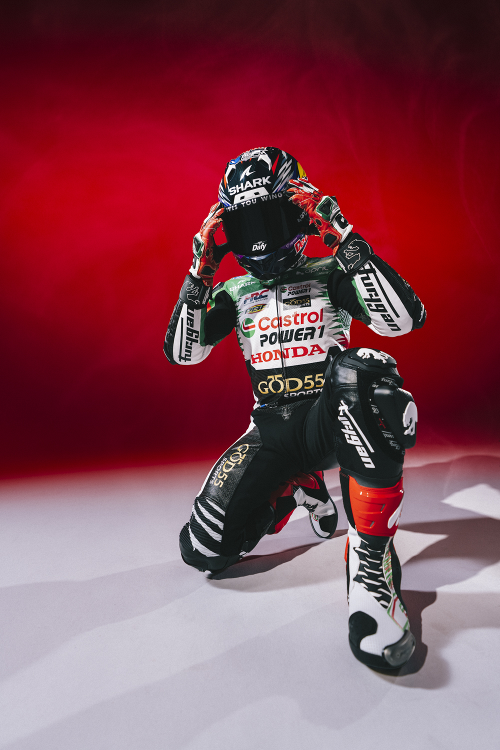 Johann Zarco casque Shark Dafy sur la tête gants rouges combinaison Castrol Honda God55 fond rouge Nicolas Jacquemin