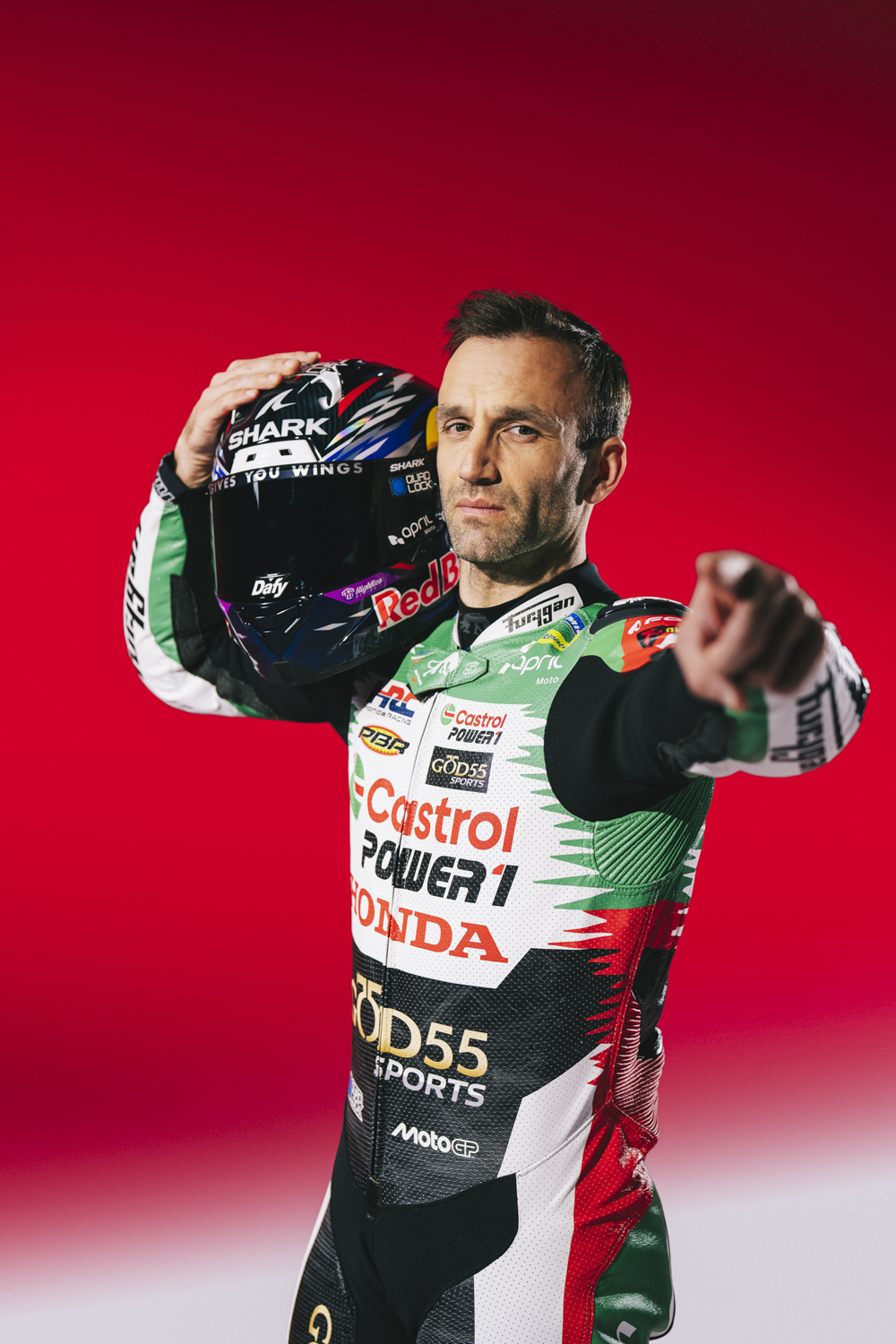 Johann Zarco pointe vers caméra casque Shark levé combinaison MotoGP media day Dafy Moto fond rouge