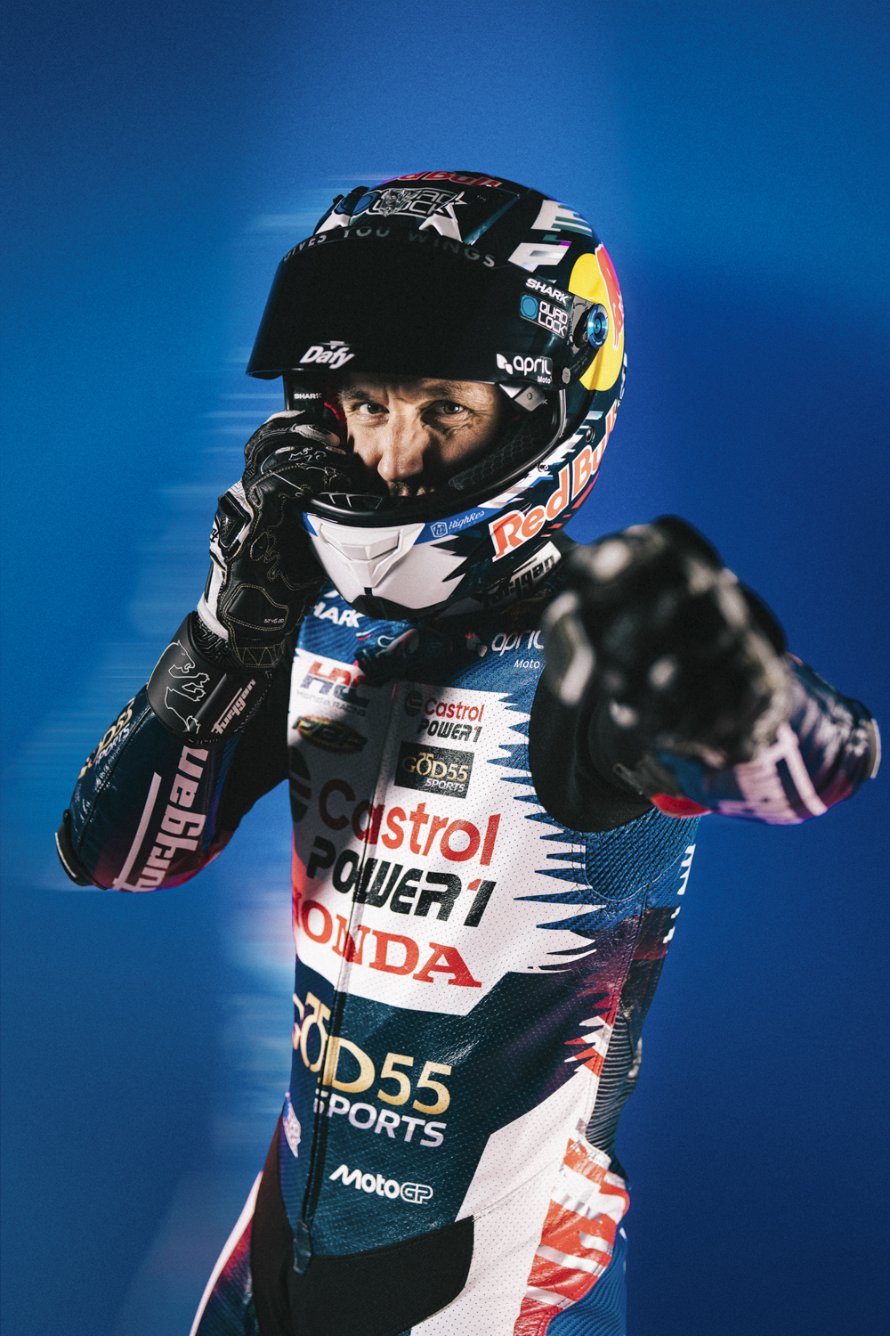 Johann Zarco casque Red Bull Shark Dafy Moto, combinaison spéciale GP de France, poing levé studio bleu — Nicolas Jacquemin photographe
