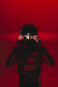 Johann Zarco enfile casque Shark Dafy regard intense gants rouges fond rouge total combinaison MotoGP