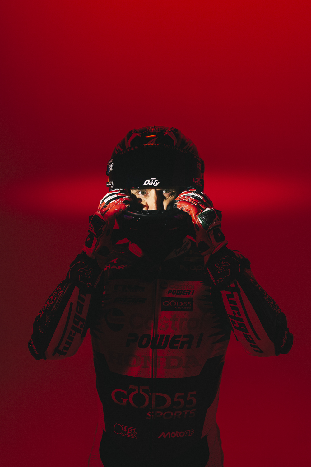 Johann Zarco enfile casque Shark Dafy regard intense gants rouges fond rouge total combinaison MotoGP