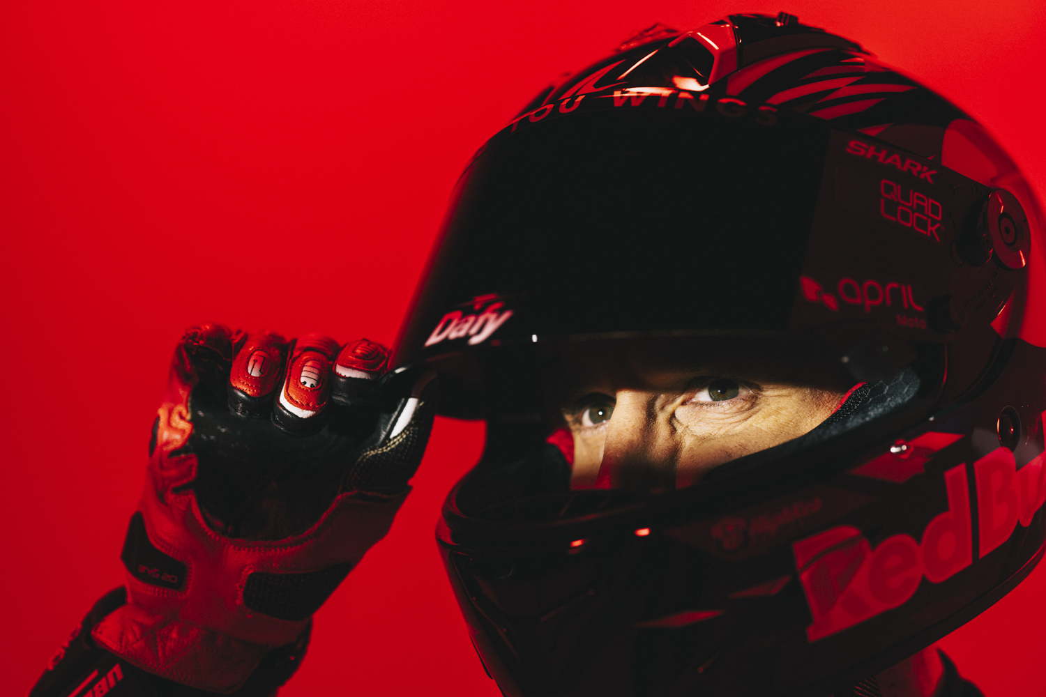 gros plan regard Johann Zarco sous casque Shark Dafy gant rouge fond rouge Nicolas Jacquemin photographe