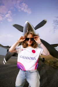 Lilou Ruel maillot Toulouse FC devant hélice avion lunettes soleil portrait aérodrome