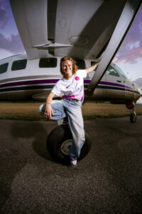 Lilou Ruel assise roue avion maillot extérieur TFC Casadora sourire ciel rose violet