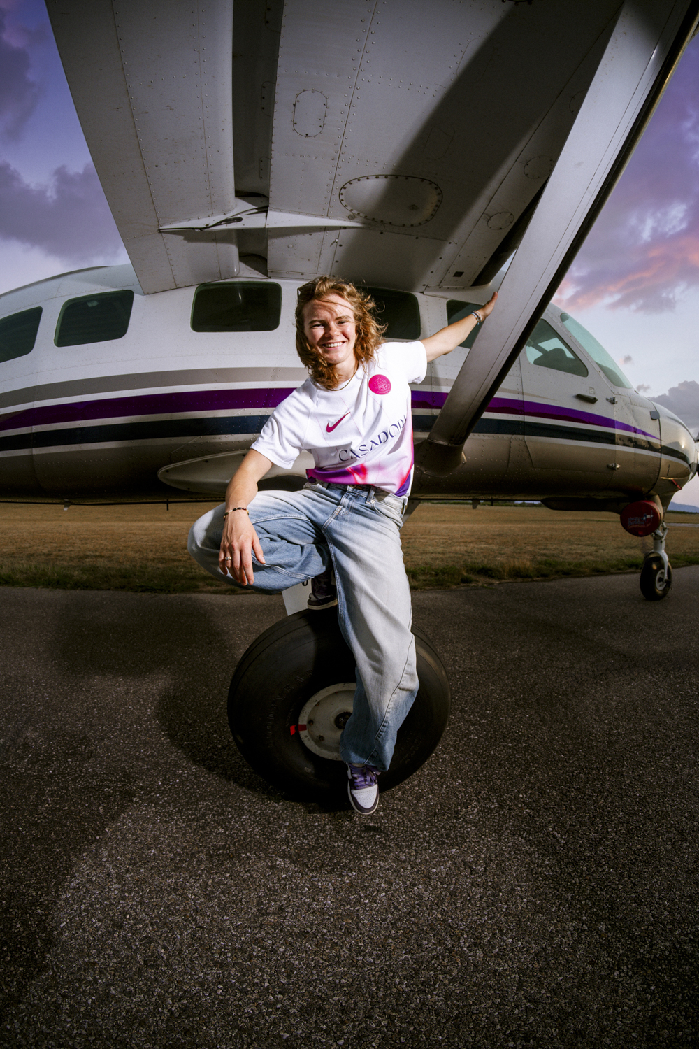 Lilou Ruel assise roue avion maillot extérieur TFC Casadora sourire ciel rose violet