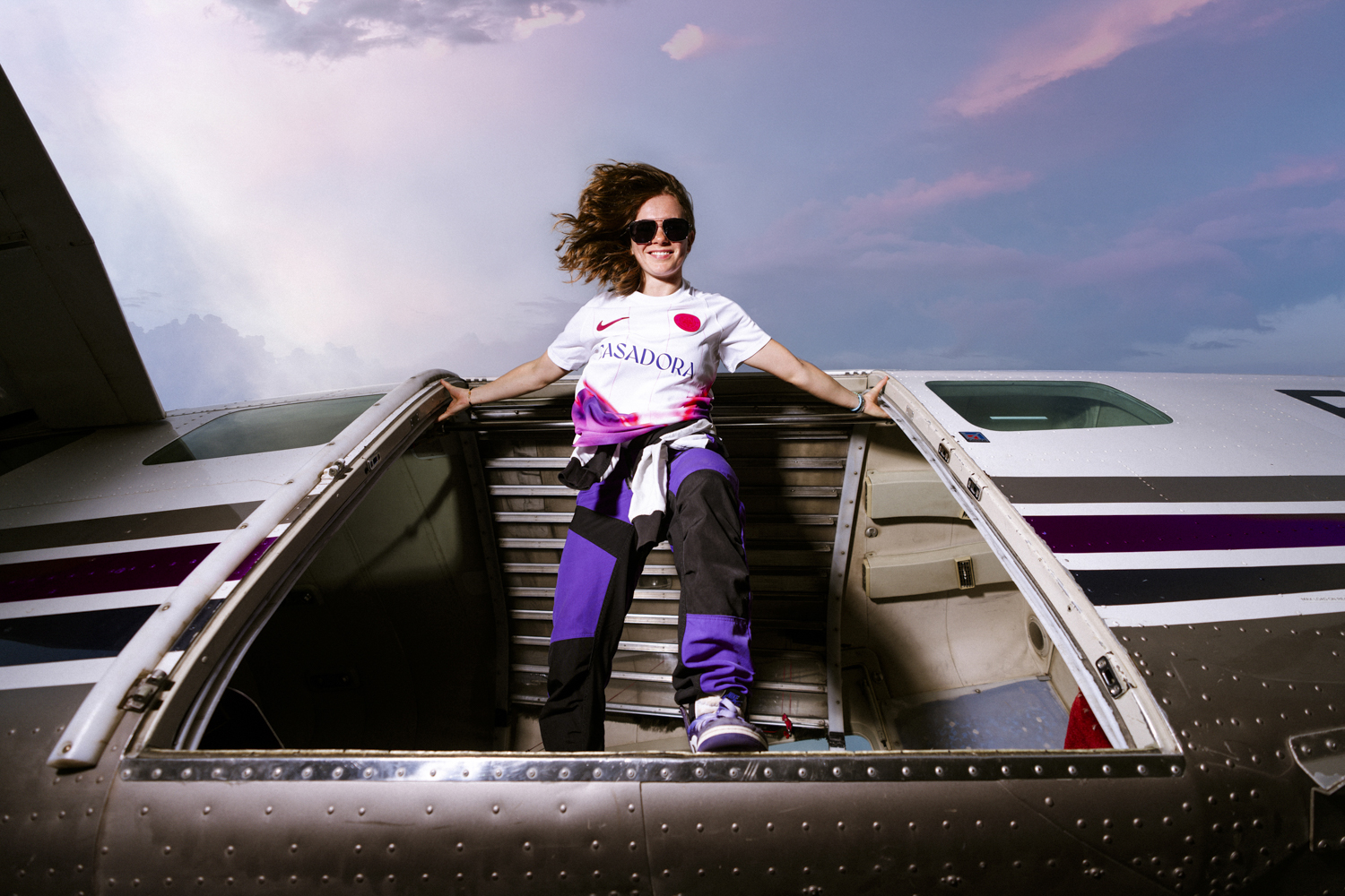 Lilou Ruel porte avion maillot Toulouse FC pantalon violet lunettes ciel coucher soleil